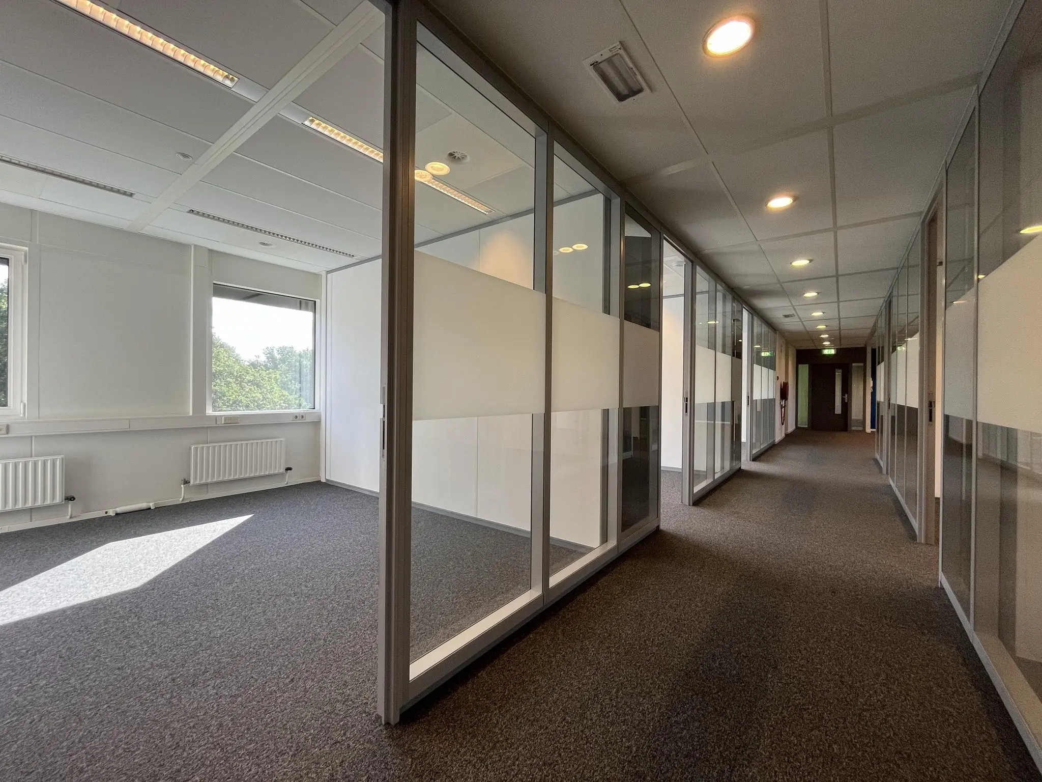 Lichte, moderne kantoorruimte aan de Baarnsche Dijk met glazen wanden en uitzicht op groen.